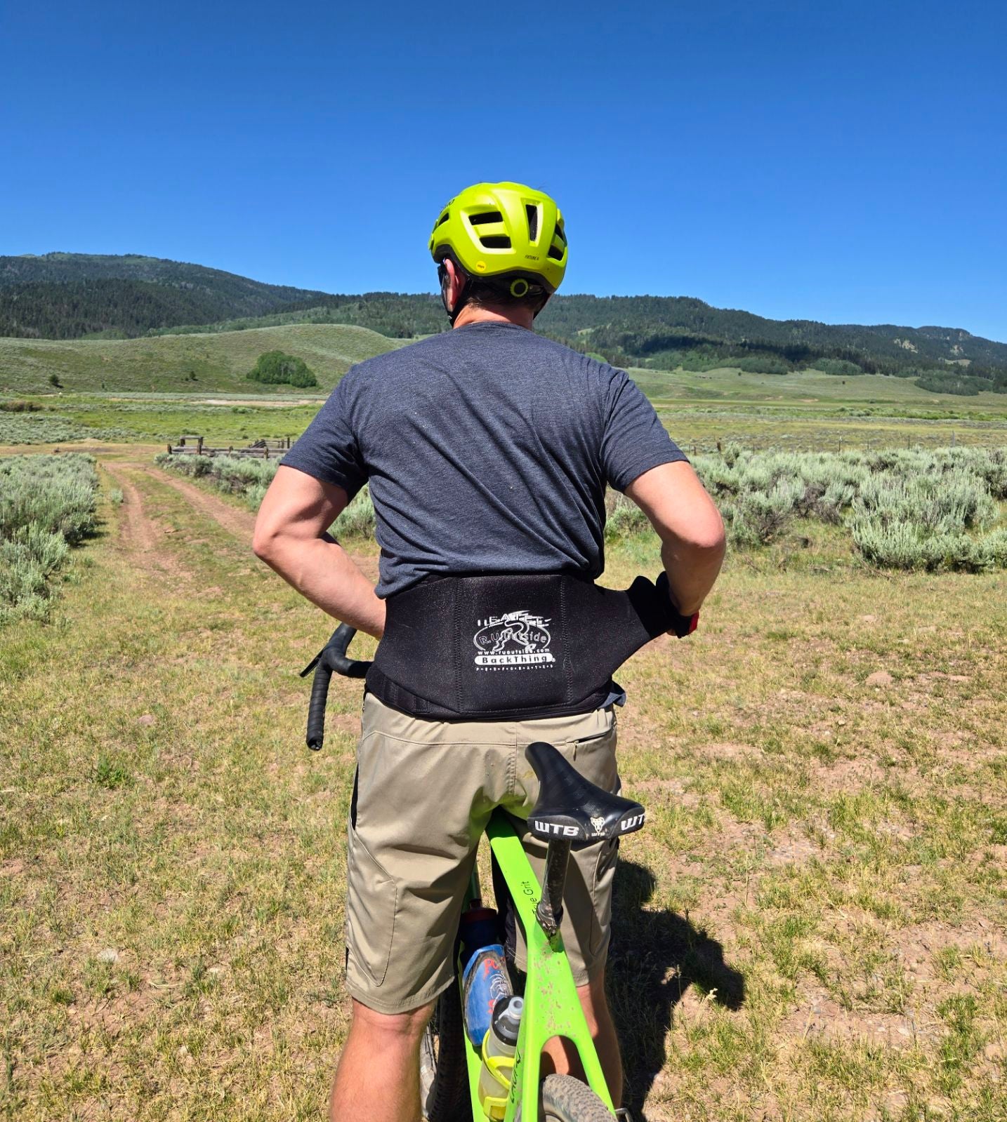 BackThing™ Back Support, neoprene sport support, shown on person riding bicycle